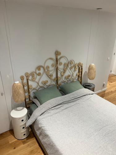 a bedroom with a large bed with a gray blanket at Petit cocon lillois:Cheminée & jardin in Lille