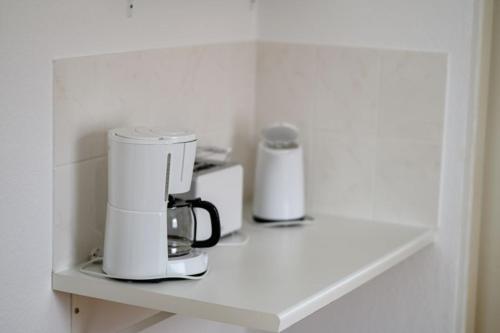 a coffee maker on a shelf in a room at Aster in Graal-Müritz