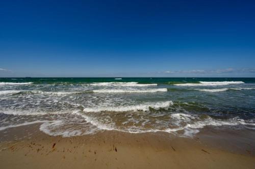 a beach with the ocean and waves at Aster in Graal-Müritz