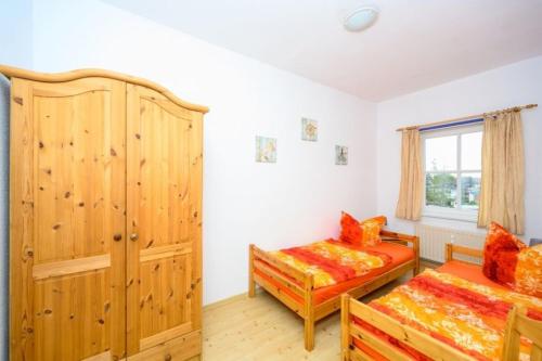 a bedroom with two beds and a wooden cabinet at Strandnelke in Graal-Müritz