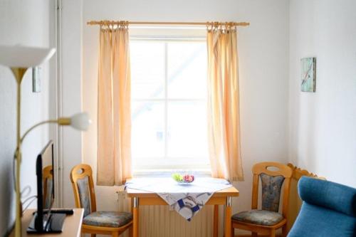 a room with a table and chairs and a window at Strandnelke in Graal-Müritz