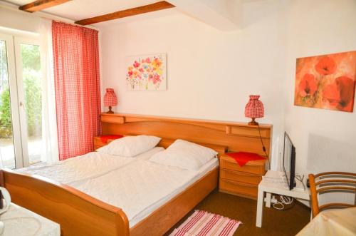 a bedroom with a bed and a television in it at Ferienhof Frohne - Zum wilden Eber in Merzen