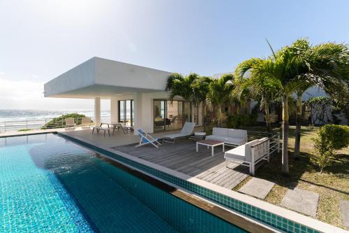 a house with a swimming pool next to the ocean at Villa de l'Océan by muse villas in Poste Lafayette