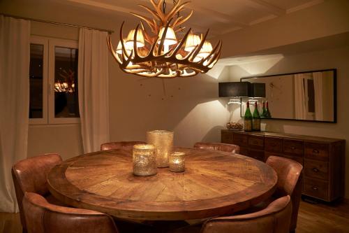 a dining room table with chairs and a chandelier at La Faya "Molerhüsli"- Gemütliches, gehobenes Ferienhaus in Muggenbrunn -Feldberg in Muggenbrunn