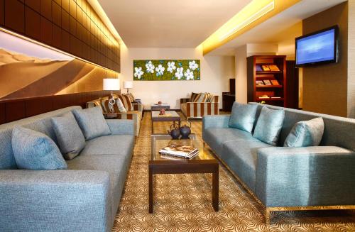 a living room with two couches and a tv at Traders Hotel, Abu Dhabi in Abu Dhabi