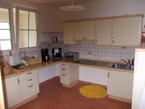 a kitchen with white cabinets and a sink at Ferienwohnung SineFinibus in Bad Grönenbach
