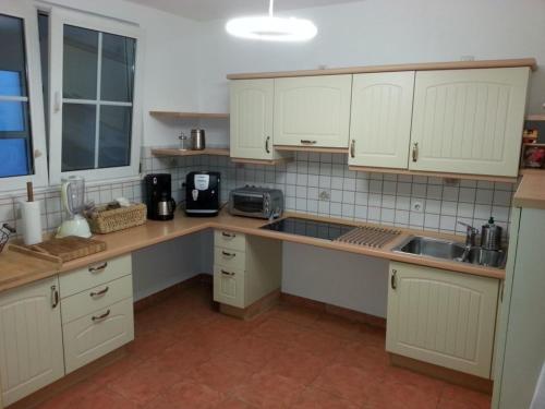 a kitchen with white cabinets and a counter top at Ferienwohnung SineFinibus in Bad Grönenbach
