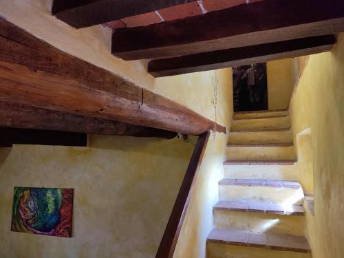 a staircase in a building with wooden beams at Podere Rinascidentro in Asciano