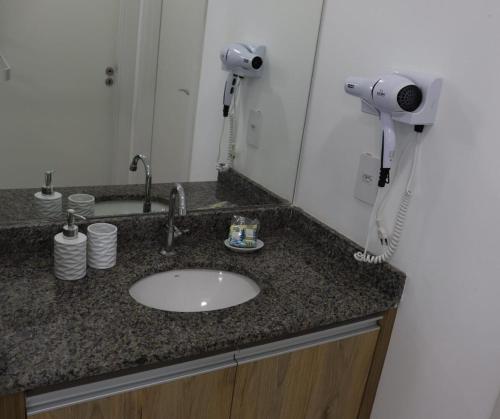 La salle de bains est pourvue d'un lavabo et d'un sèche-cheveux. dans l'établissement Canário - Apartamento perto do Allianz Park e Metrô, à São Paulo