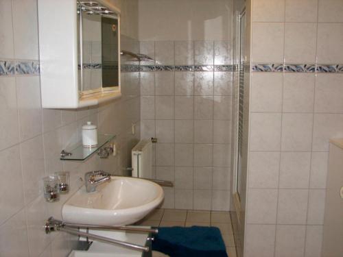 a white bathroom with a sink and a shower at Hering in Grossenbrode