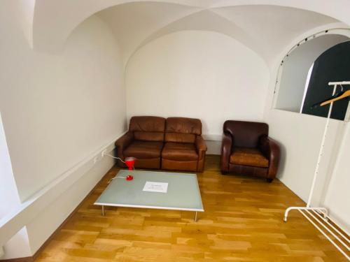 グラーツにあるWohnung, 3 Zimmer, eines davon Durchgangszimmer, ruhig, Graz Zentrumのソファとテーブルのあるリビングルーム