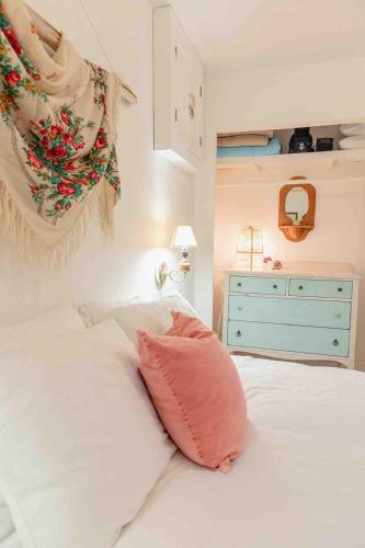a bedroom with a white bed with a pink pillow at The Wayward Inn in Chemainus