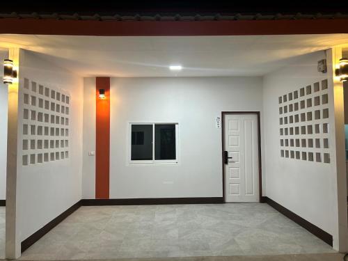 a hallway with white walls and a white door at V Rich วีริชเพลส ร้อยเอ็ด in Ban Non Muang