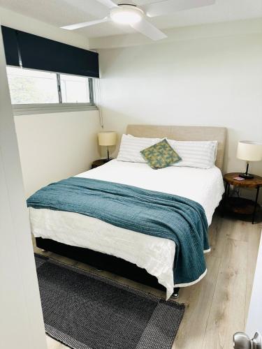 a bedroom with a bed with a blue blanket at Paddington chic at Five Ways in Sydney