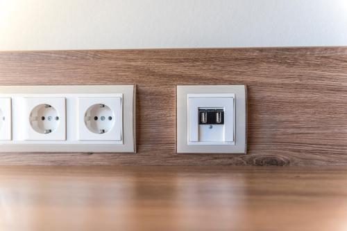 two white electrical outlets on a wooden wall at Bavaria Boutique Hotel in Munich