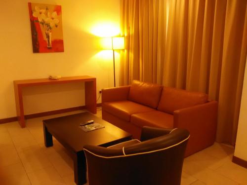 a living room with a couch and a coffee table at Gloria Swiss Hotel & Apartment Sandakan in Sandakan