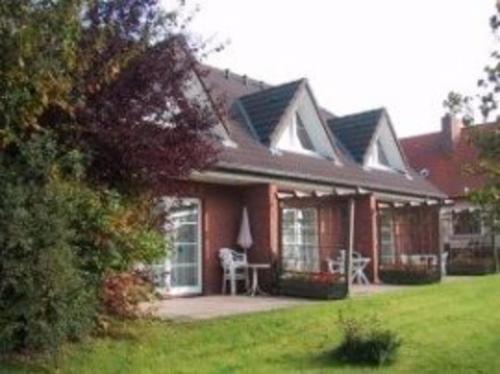 une grande maison avec un porche et une pelouse dans l'établissement To Hus, Reihenhaus 7, à Kellenhusen