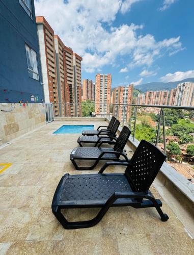 a row of chairs sitting on the roof of a building at Acogedor y cómodo apartamento in Sabaneta