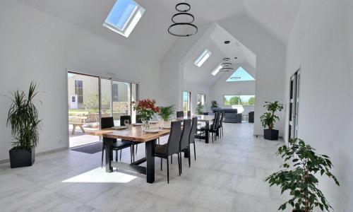 a dining room with a table and chairs at TY MENEZ HEOL - Magnifique villa avec piscine in Ploudalmézeau
