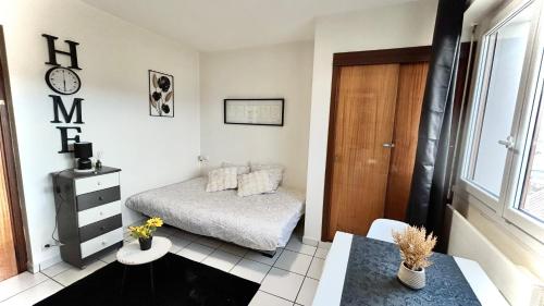 une petite chambre avec un lit et une table dans l'établissement Studio cosy Vue imprenable Aix Les Bains, à Aix-les-Bains