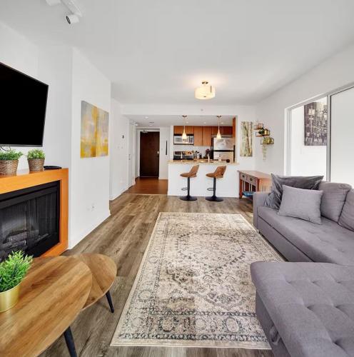 a living room with a couch and a fireplace at Stylish Condo in Downtown in Vancouver