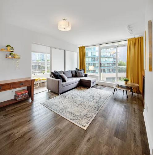 a living room with a couch and a table at Stylish Condo in Downtown in Vancouver