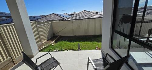 a balcony with two chairs and a fence at Luxury Five Bedroom House at the Ponds in Schofields