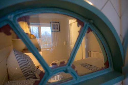 a reflection of a room with a bed and a mirror at Windhauch in Westermarkelsdorf