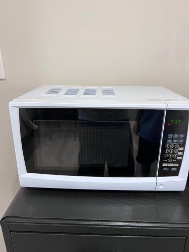 a white microwave sitting on top of a black microwave oven at Cozy Ensuite Room with Amenities & Private Entrance in Auckland