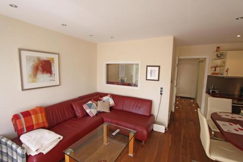 een woonkamer met een rode bank en een tafel bij Strandidyll, 54 - Typ A1 in Grömitz