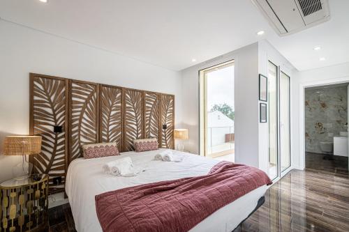 a bedroom with a large bed and a large window at BeGuest Albufeira Luxus Villa in Albufeira