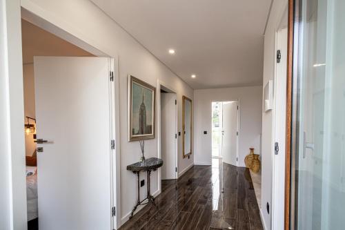 a hallway with white walls and wood flooring at BeGuest Albufeira Luxus Villa in Albufeira