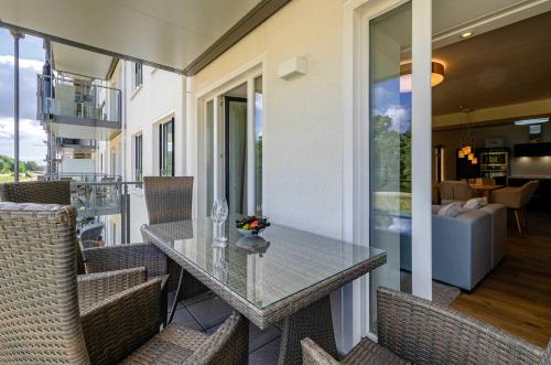 a glass table on the balcony of a house at FeWo Prora - Moin in Binz
