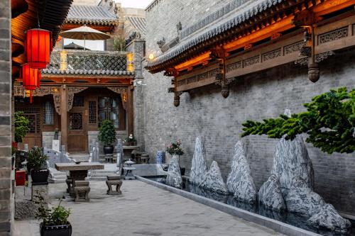 a courtyard of a building with a table and benches at Shanxi Merchant Mansion in Pingyao