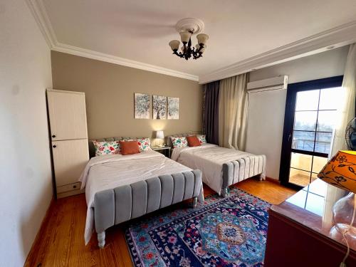 a bedroom with two beds and a rug at Vintage Charm & Spacious Comfort in Zayed 2000 - only families & single travelers in Sheikh Zayed