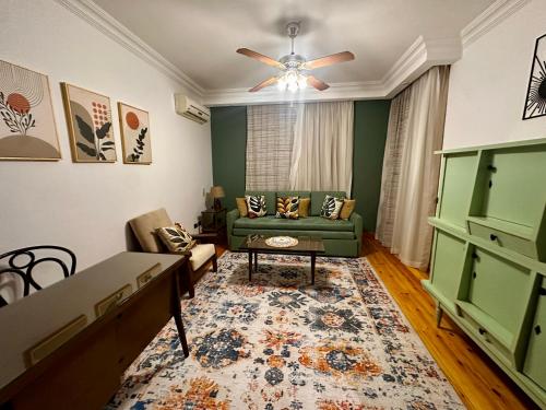 a living room with a green couch and a ceiling fan at Vintage Charm & Spacious Comfort in Zayed 2000 - only families & single travelers in Sheikh Zayed