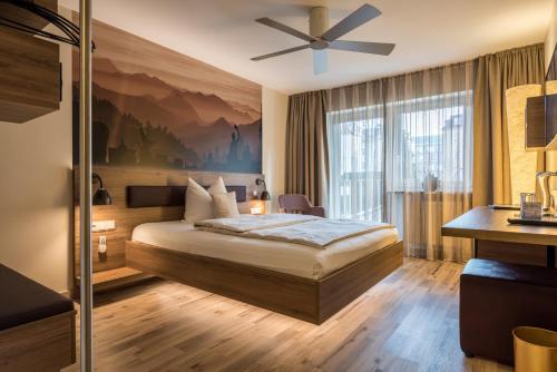 ミュンヘンにあるバーバリア ブティック ホテルのベッド1台、天井ファンが備わる客室です。