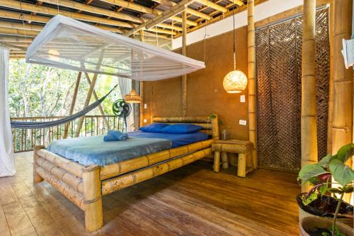 a bedroom with a bed with a mosquito net at Finca La Selvita Chocolate experience in Buritaca
