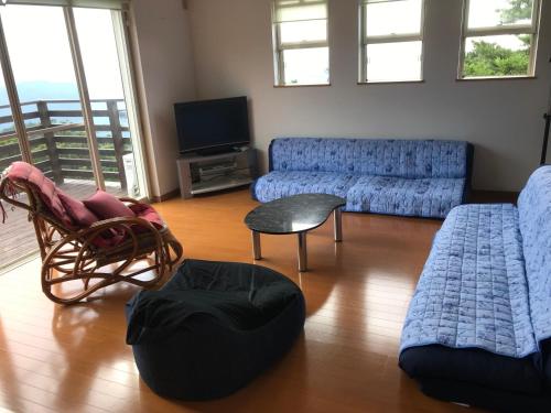 a living room with blue couches and a television at Ise Sky Villa / Vacation STAY 2021 in Ise