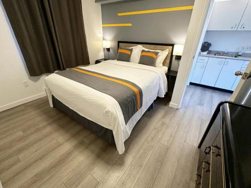 a bedroom with a large bed and a kitchen at Duncan Motel in Duncan