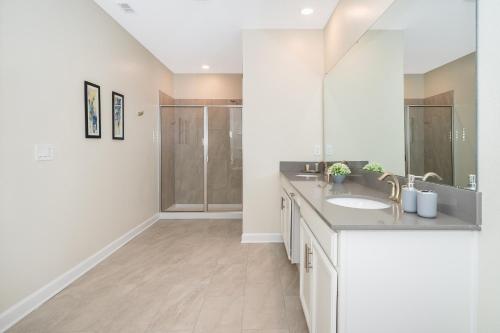 a white bathroom with a sink and a shower at Fabulous Villas 5 minutes away from Disney! in Kissimmee