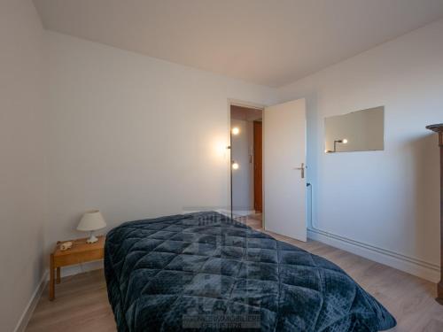 une chambre avec un grand lit avec une couverture bleue dans l'établissement Appartement 4 pièces avec balcon face mer, proche plage et commerces, idéal famillies - FR-1-197-199, à Les Sables-dʼOlonne