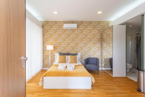 a bedroom with a large bed and a blue chair at BeGuest Benfica Modern Flat in Lisbon