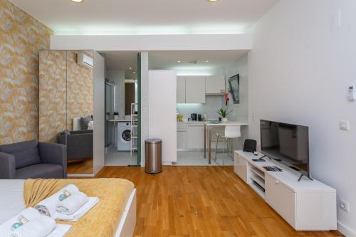 a living room with a bed and a tv and a kitchen at BeGuest Benfica Modern Flat in Lisbon