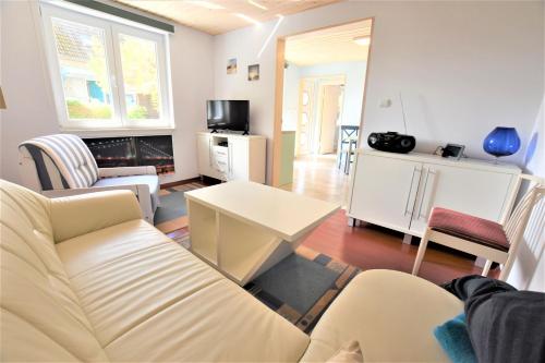 ein Wohnzimmer mit Sofa und Tisch in der Unterkunft Bungalow Janik in Dahme