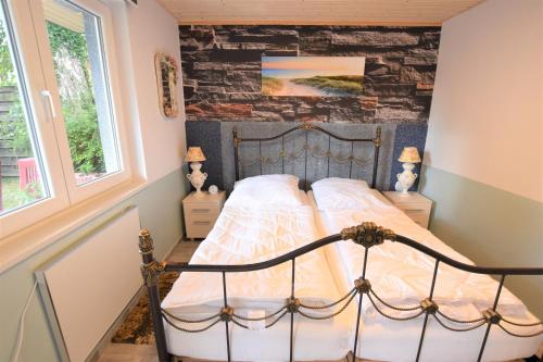 ein Schlafzimmer mit einem Bett und einer Steinwand in der Unterkunft Bungalow Janik in Dahme