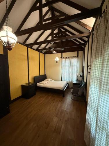 a bedroom with a bed and a chair in a room at Fresia Villa & Camping in Beranang