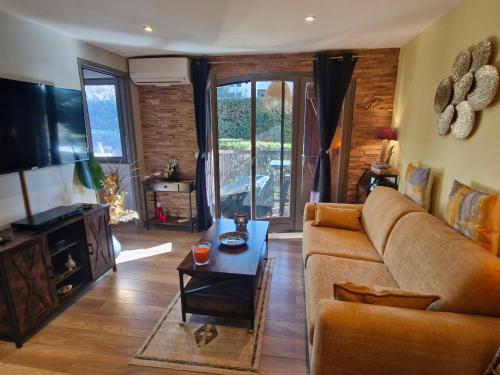 un salon avec un canapé et une télévision dans l'établissement Appartement 2 pièces climatisé, belle terrasse, parking privé, proche centre-ville et plage Sainte-Maxime - FR-1-780-43, à Sainte-Maxime