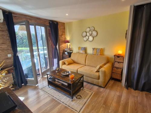 un salon avec un canapé et une table dans l'établissement Appartement 2 pièces climatisé, belle terrasse, parking privé, proche centre-ville et plage Sainte-Maxime - FR-1-780-43, à Sainte-Maxime