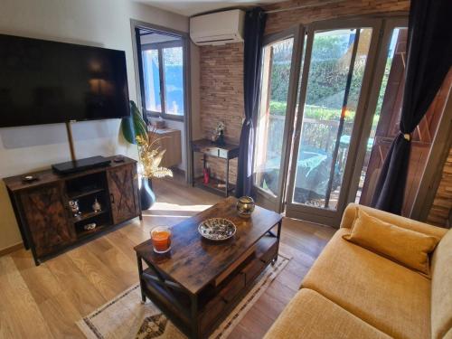 un salon avec un canapé et une table basse dans l'établissement Appartement 2 pièces climatisé, belle terrasse, parking privé, proche centre-ville et plage Sainte-Maxime - FR-1-780-43, à Sainte-Maxime